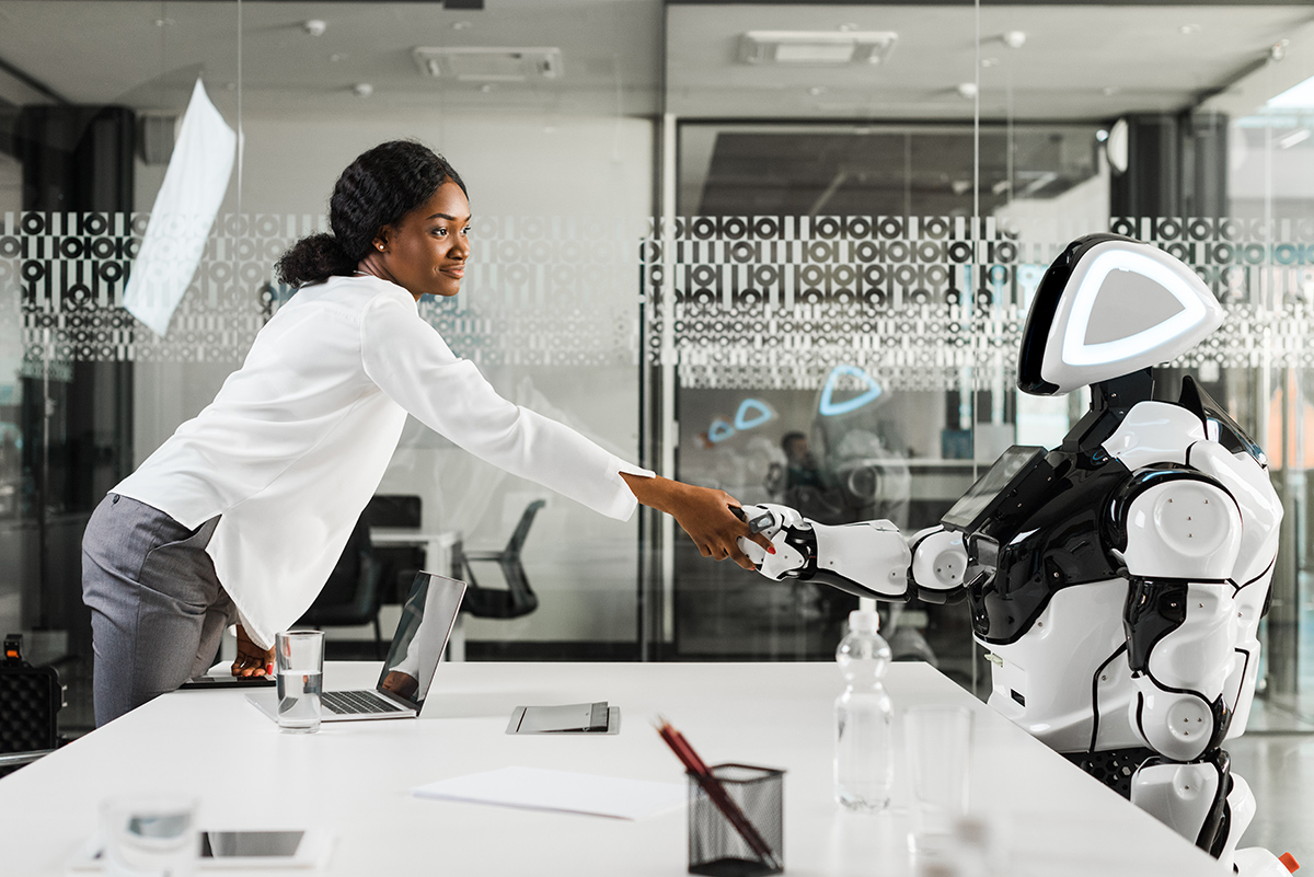 Eine Frau gibt einem Roboter die Hand. Im Beitrag geht es darum, warum Websites & SEO trotz KI-Zeitalter unverzichtbar bleiben