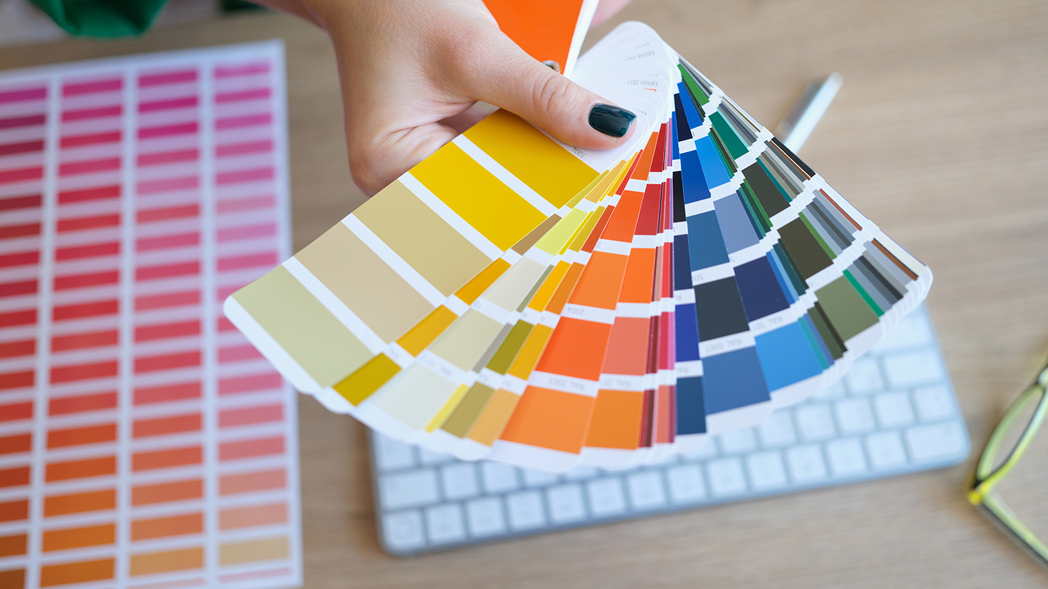 Farbpsychologie im Webdesign: Warum Farben unsere Kaufentscheidung beeinflussen können. Farbpsychologie im Webdesign:Eine Frau hält eine Farbkarte in der Hand. Sie sucht vermutlich die Farben für ihre Marke und ihre Website aus.