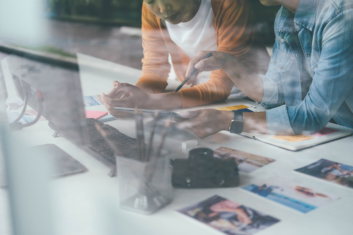 Auf dem Foto sieht man zwei Mitarbeitende einer Webdesign Agentur. Sie tauschen sich über die Erstellung einer professionellen Website aus.